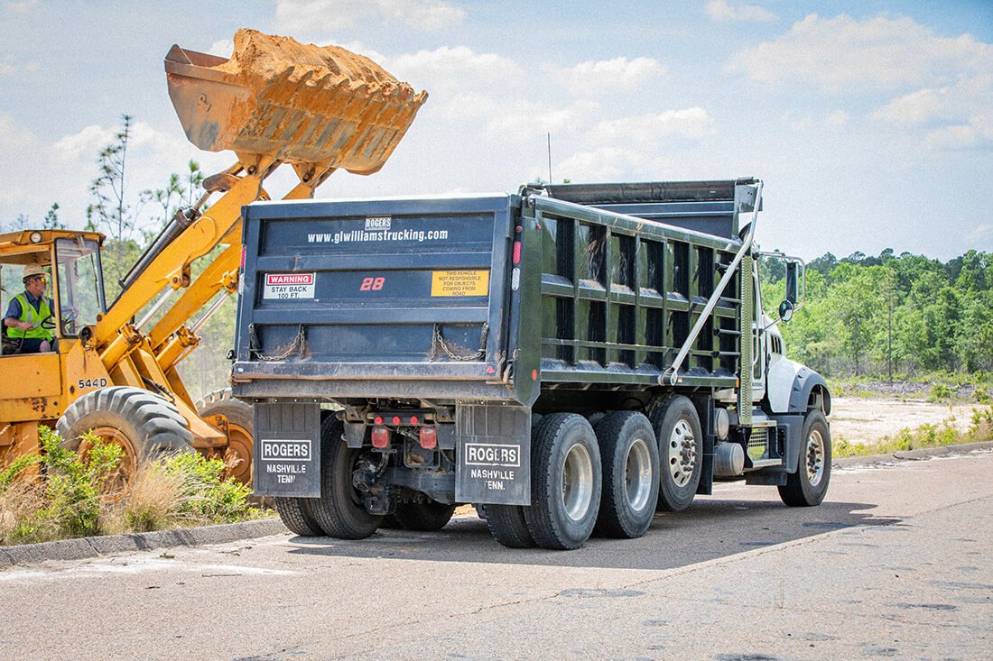 front loader and truck excavating land