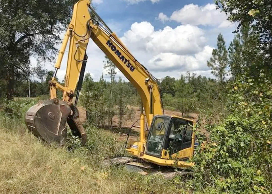 front loader and truck excavating land