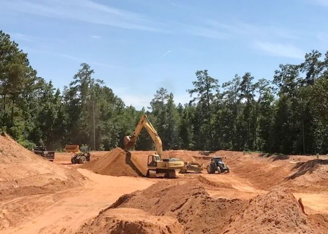 front loader and truck excavating land